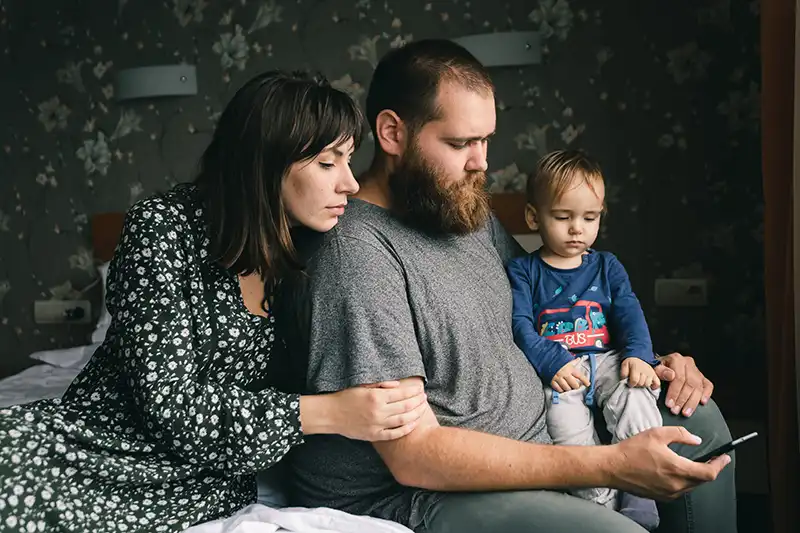 Una pareja joven que sufre infertilidad secundaria se sienta con su hijo