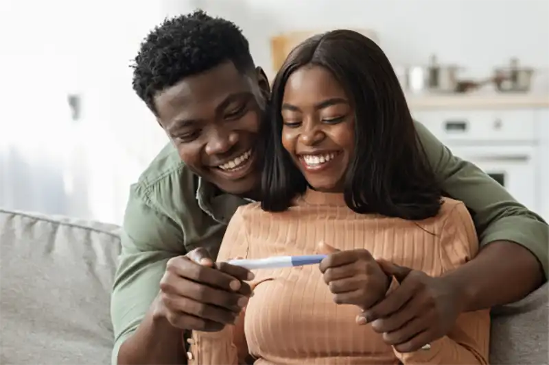 african american couple looking at pregnancy test