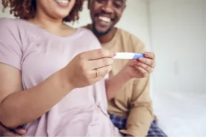 man and woman looking at pregnancy test